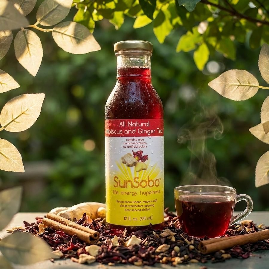 SunSobo bottle surrounded by hibiscus, ginger, cinnamon and cloves with a steaming cup of brewed tea